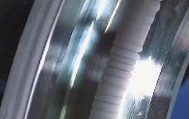 An electrical current that discharges through a bearing produces damage of this sort called fluting.