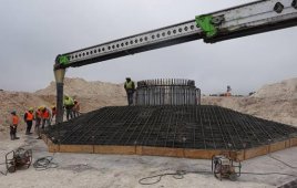 Construction workers pour concrete into a wind turbine base at the Santa Rita East wind farm near San Angelo, TX.